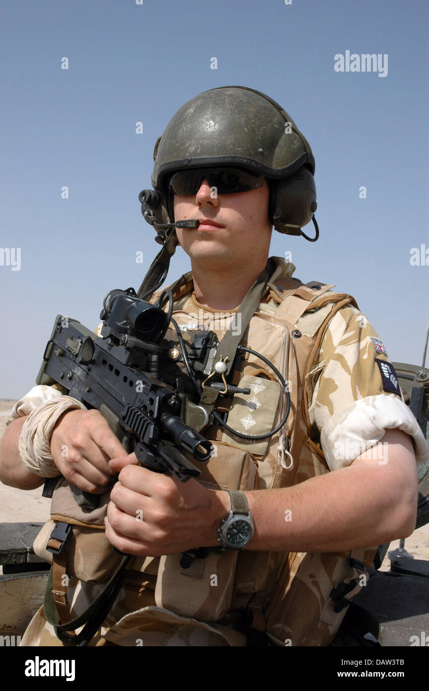 The British commander of a battle tank 'Challenger 2' of the British army is pictured on patrol in the desert near Basrah, Iraq, June 2006. The soldier is part of the 'Queen's Royal Hussars' and carries a protection vest and a SA80A rifle. Photo: Carl Schulze Stock Photo