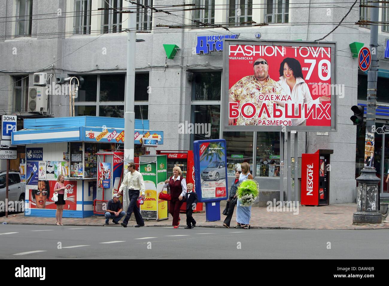 The street scene shows a kiosk, billboards and passerbys in Odessa