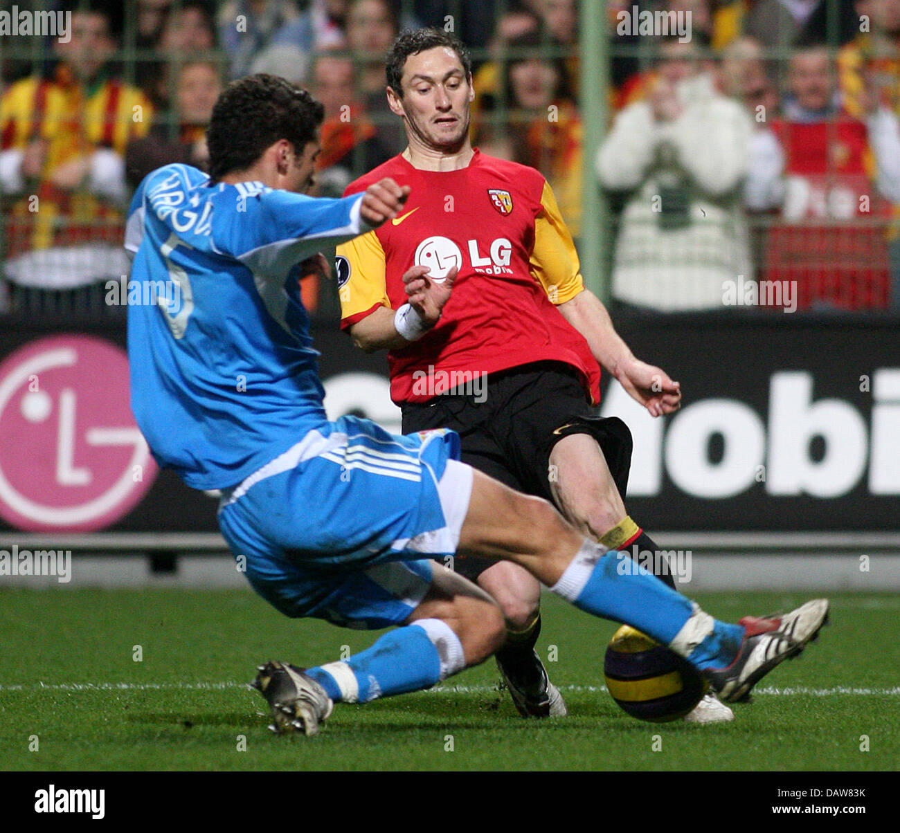 Karim Haggui (L) of Leverkusen fouls Ahmed Madouni of Lens during the UEFA Cup match RC Lens vs Bayer 04 Leverkusen at Félix-Bollaert Stadium in Lens, France, Thursday 08 March 2007. Haggui was subsequently expelled from the pitch while Lens scored the penalty shot. Leverkusen lost to Lens by 1-2. Photo: Felix Heyder Stock Photo