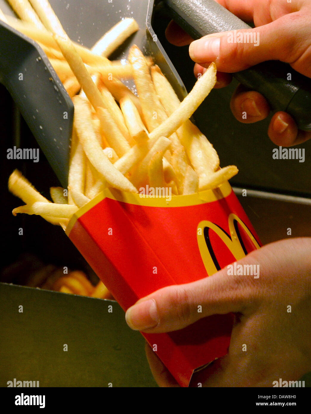 An employee scoops french fries into a box in a McDonald's branch
