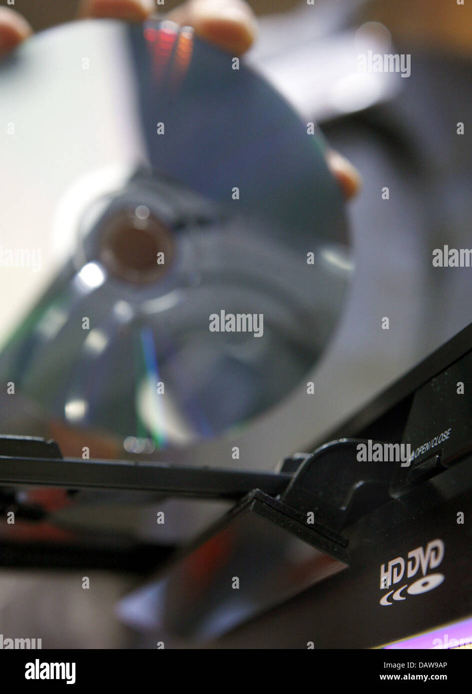 A person inserts a HD-DVD into a player at the 'CeBIT 2007' trade fair in Hanover, Germany, Thursday, 15 March 2007. The two formats HD-DVD and Blue-ray continue to compete for the succession of the CD and DVD systems at the world's largest trade fair showcasing digital IT and telecommunications solutions for home and work environments. The CeBIT runs from 15th until 21st March 200 Stock Photo