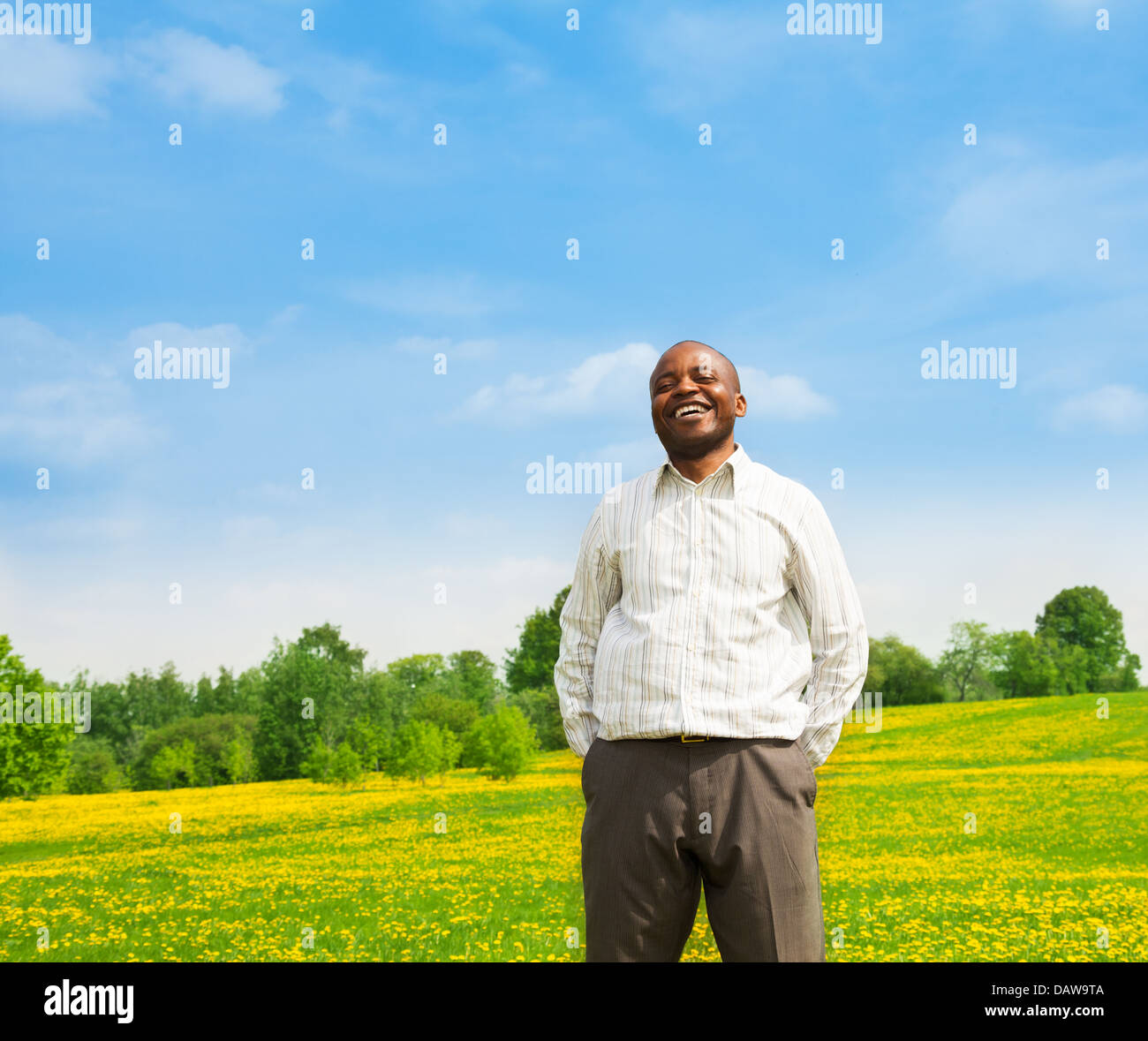 Happy confident laughing black man wearing shirt standing outside in the  park on the yellow dandelion field Stock Photo - Alamy, image size:1300x1179