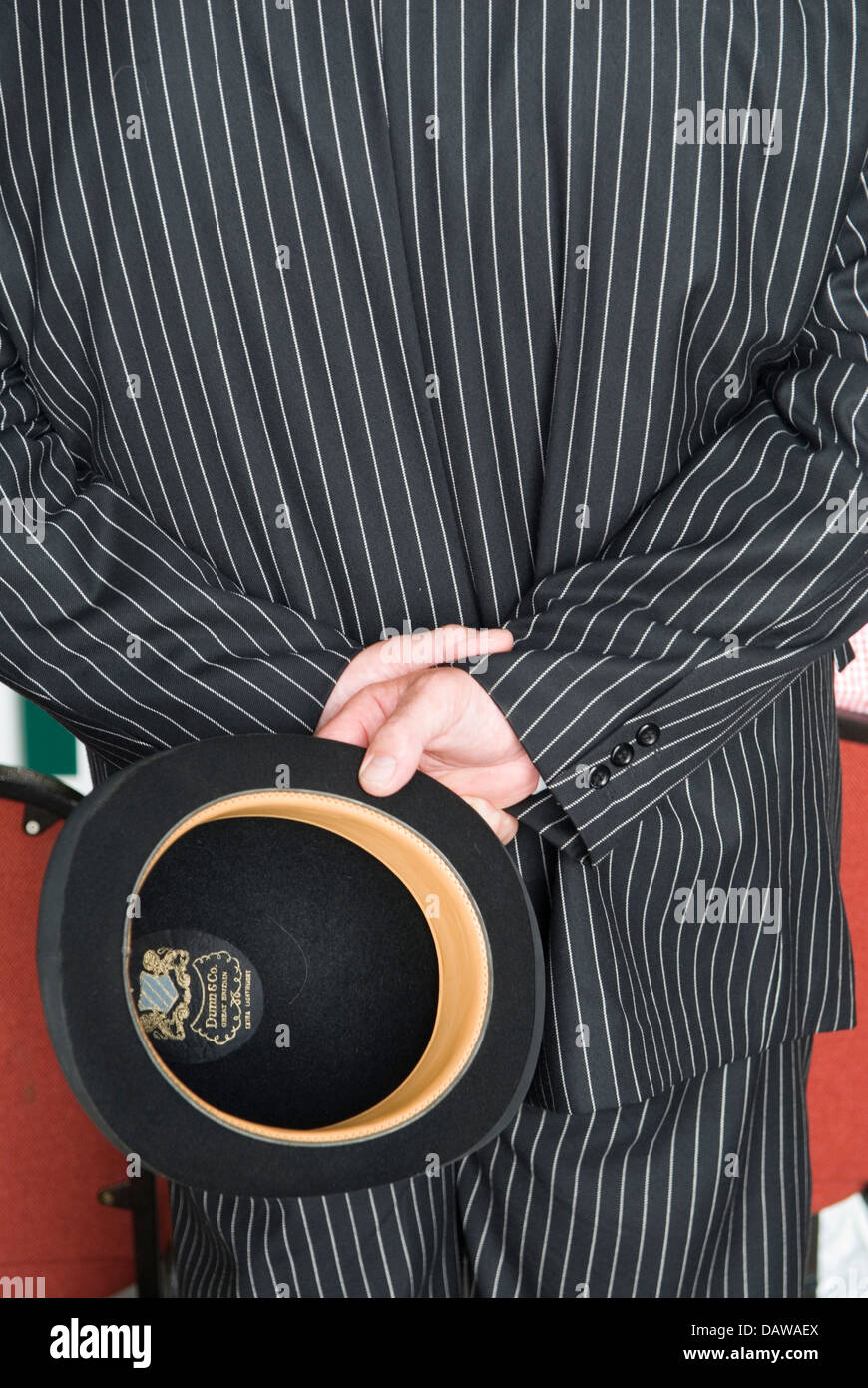 Dress Code 2010s. Man in pinstripe suit carrying a bowler hat at the