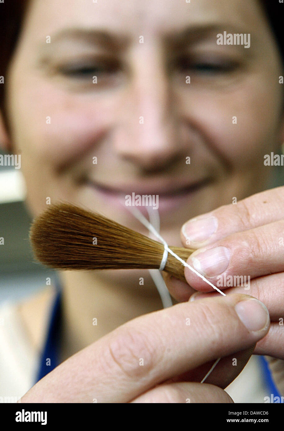 Employee Manuela Scharf binds the animal hairs for a brush head