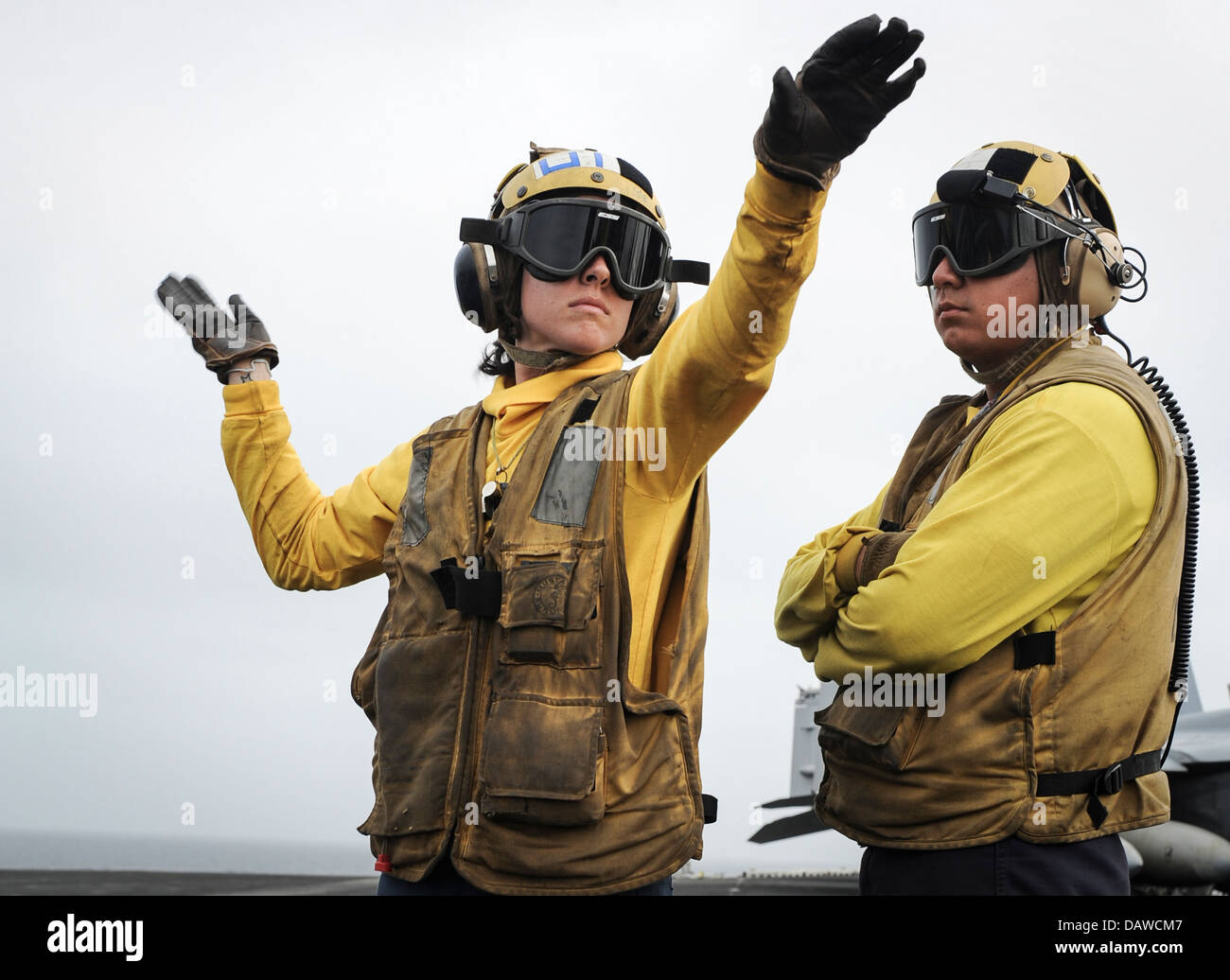 A US Navy Aviation Boatswain’s Mate receives training on aircraft hand signals on the flight deck of the aircraft carrier USS Nimitz July 15, 2013 in the Gulf of Oman. Stock Photo