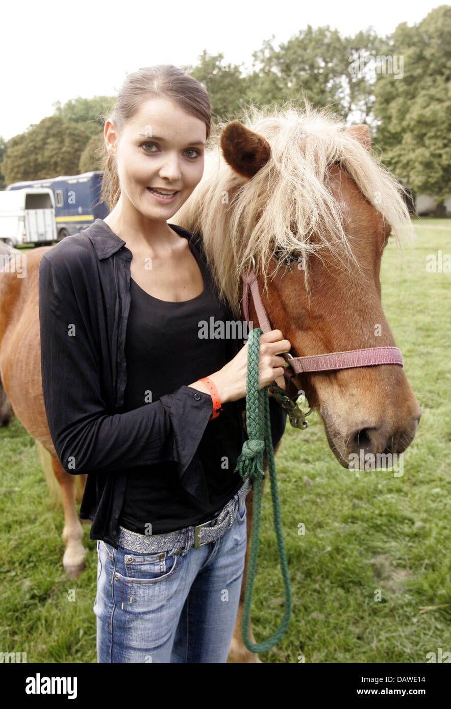 (dpa file) - German actress Christiane Klimt (R) smiles next to a horse during the 5th charity horse race at the racecourse in Cologne-Weidenpesch, Germany, 24 September 2006. Traditionally lots of celebrities came. Since 1954 the 'Kinderschutzbund Cologne' stands up for the improvement of childrens' and families' living conditions. Photo: Joerg Carstensen Stock Photo
