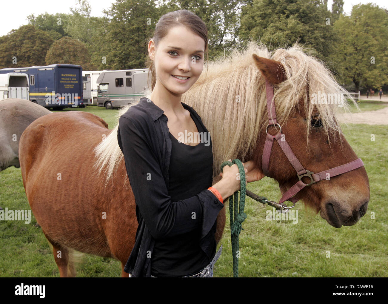 (dpa file) - German actress Christiane Klimt smiles next to a horse during the 5th charity horse race at the racecourse in Cologne-Weidenpesch, Germany, 24 September 2006. Traditionally lots of celebrities came. Since 1954 the 'Kinderschutzbund Cologne' stands up for the improvement of childrens' and families' living conditions. Photo: Joerg Carstensen Stock Photo