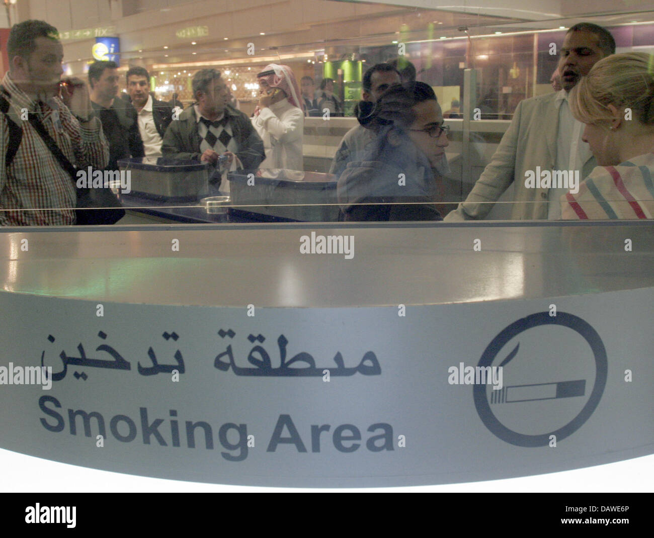 Smokers gather at the smoking area of the 24-hours mall located ahead of  the departure gates at the International Airport in Dubai, United Arab  Emirates, Friday 30 March 2007. The airport is