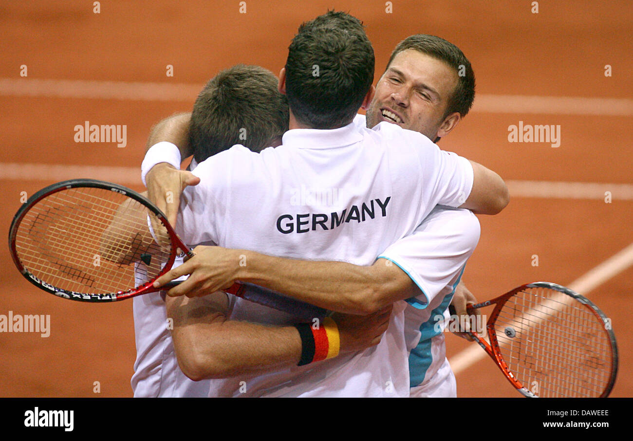 German tennis double Alexander Waske (R), Michael Kohlmann (L) and team captain Patrik Kuehnen embrace each other after beating the Belgian double Norman and Rochus in the Davis Cup quarter-finals match at Sleuyter Arena in Ostende, Belgium, Saturday 07 April 2007. The German double won 4-6, 6-2, 6-3 and 6-1. Due to their victory Germany enters semifinals early. Photo: Felix Heyder Stock Photo