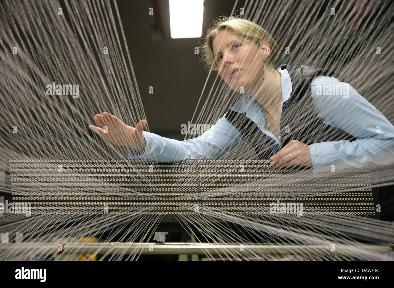 A worker operates a machine at the ADO Gardinenwerke weaving mill in