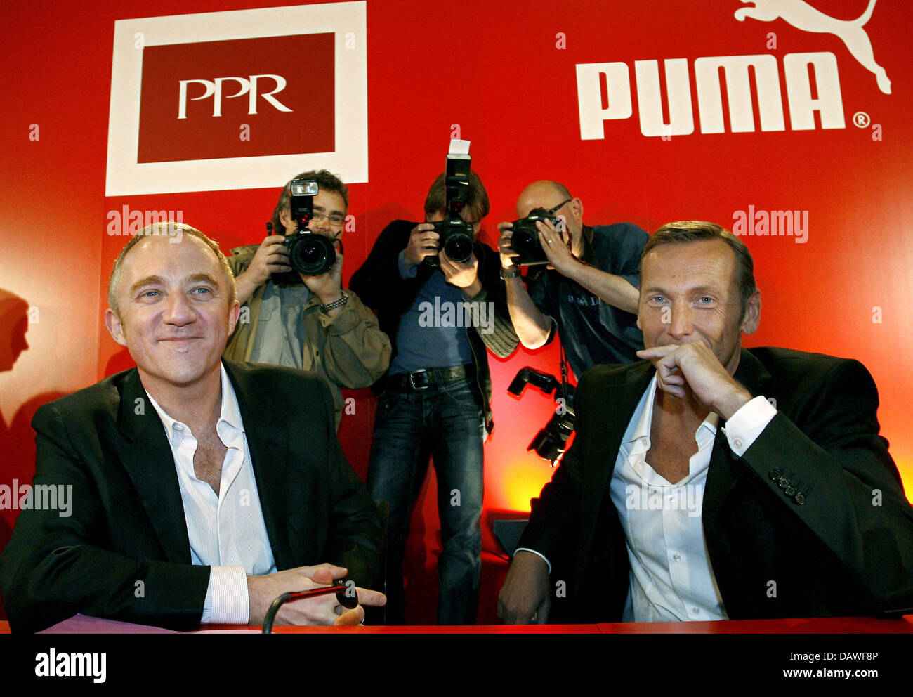 Photographers stand behind Puma AG CEO Jochen Zeitz (R) and French luxury  group Pinault-Printemps-Redoute's (PPR) chairman Francois-Henri Pinault  prior to a press conference in Nuremberg, Germany, Thursday 12 April 2007.  PPR, owner