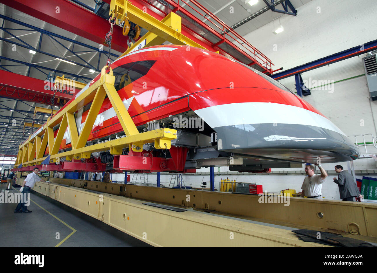 The TR09, a 'Transrapid' maglev train designed for a possible maglev service in Munich, is transferred to a special transporter by ThyssenKrupp employees in Kassel, Germany, 17 April 2007. The 25m long front section of the train weighs 50 tons and will be brought to the maglev test track in the Emsland region, north west Germany. The transfer is planned to take two nights. The othe Stock Photo