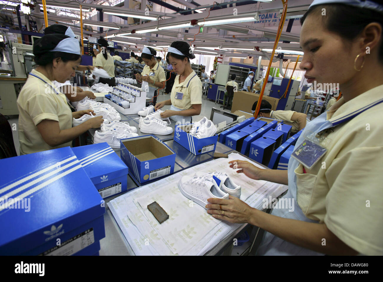 Female workers pack trainers into boxes at an Adidas plant in Ho Chi Minh  City,Vietnam, 29 March 007. Photo: Peter Kneffel Stock Photo - Alamy