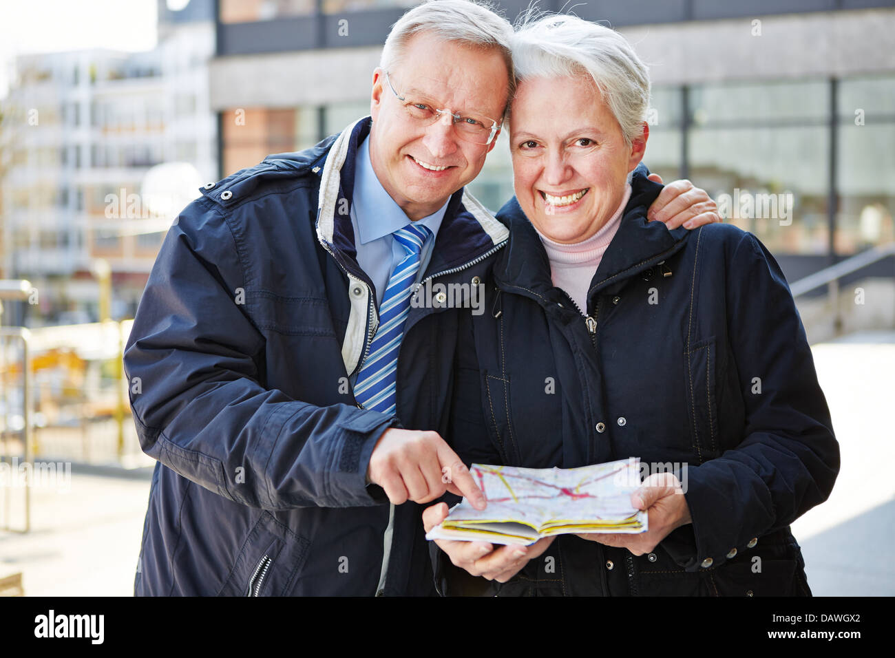 Two happy seniors on city trip with map Stock Photo