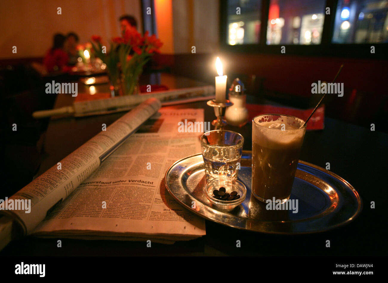 A latte macchiato and a gals of water pictured on a table of a cafe in Hamburg, Germany, 12 January 2007. The most popular hot drink literally means 'marked milk' and is made of frothed up milk with an espresso shot added to create the eponymous mark. Photo: Kay Nietfeld Stock Photo