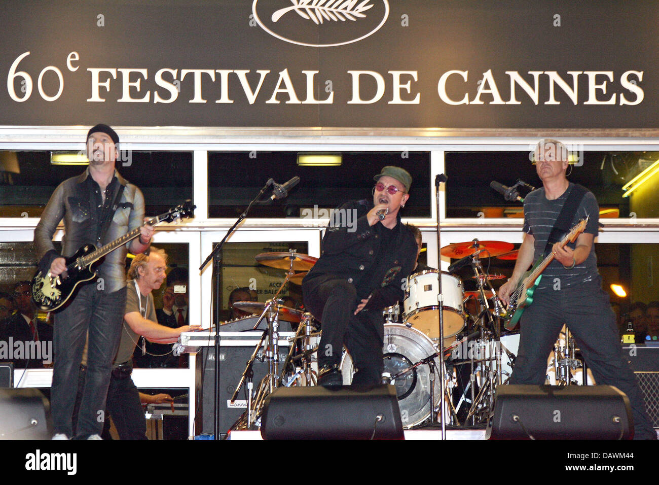 U2 band members (L-R) The Edge, a sub keyboarder, Bono, Larry Mullen Jr. (hidden) and Adam Clayton perform on the red carpet for a gala screening of Irish director Catherine Owens' and US director Mark Pellington's film 'U2 3D' at the 60th Cannes Film Festival in Cannes, France, 19 May 2007. Photo: Hubert Boesl Stock Photo