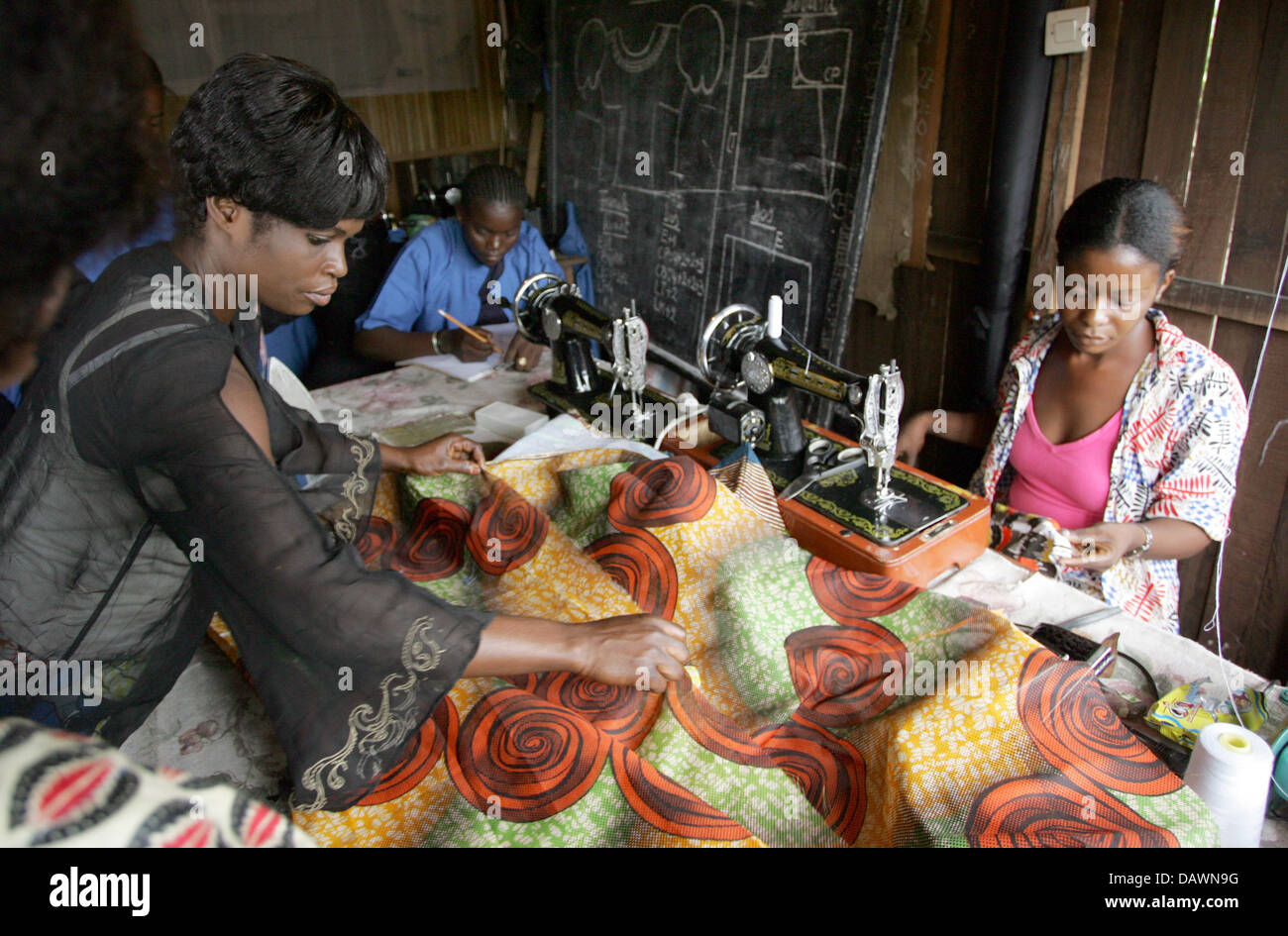 Young women process textiles with sewing machines at a sewing room run together with the Stuttgart based organisation 'Christliche Fachkraefte International' (CFI) in a Kinshasa shanty town, Democratic Republic of the Congo, 4 May 2007. In two groups the women, who partly work as prostitutes, learn the art of sewing on 20 machines. Photo: Rainer Jensen Stock Photo