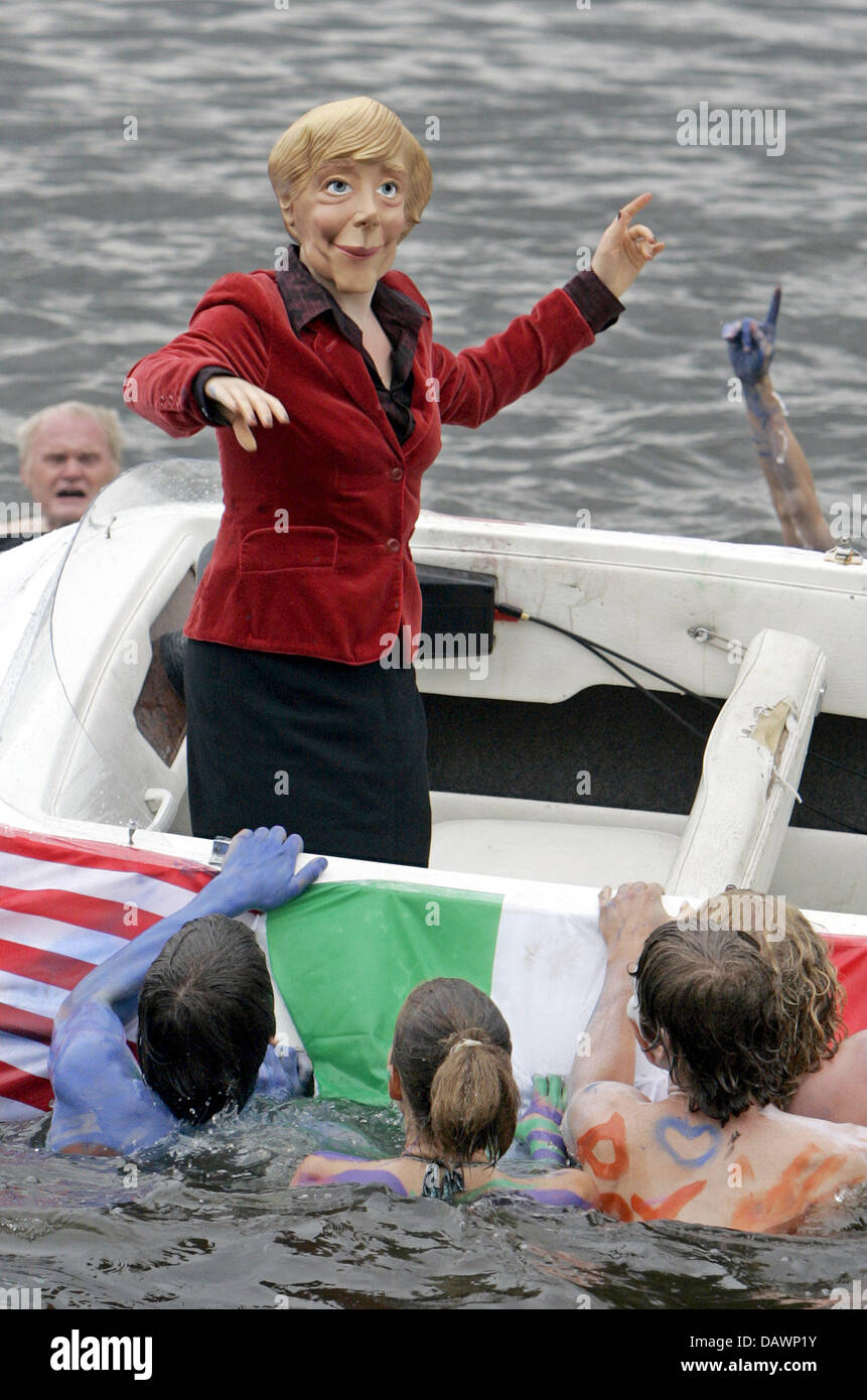 Members of Attac board a boat with caricatures of Angela Merkel during ...