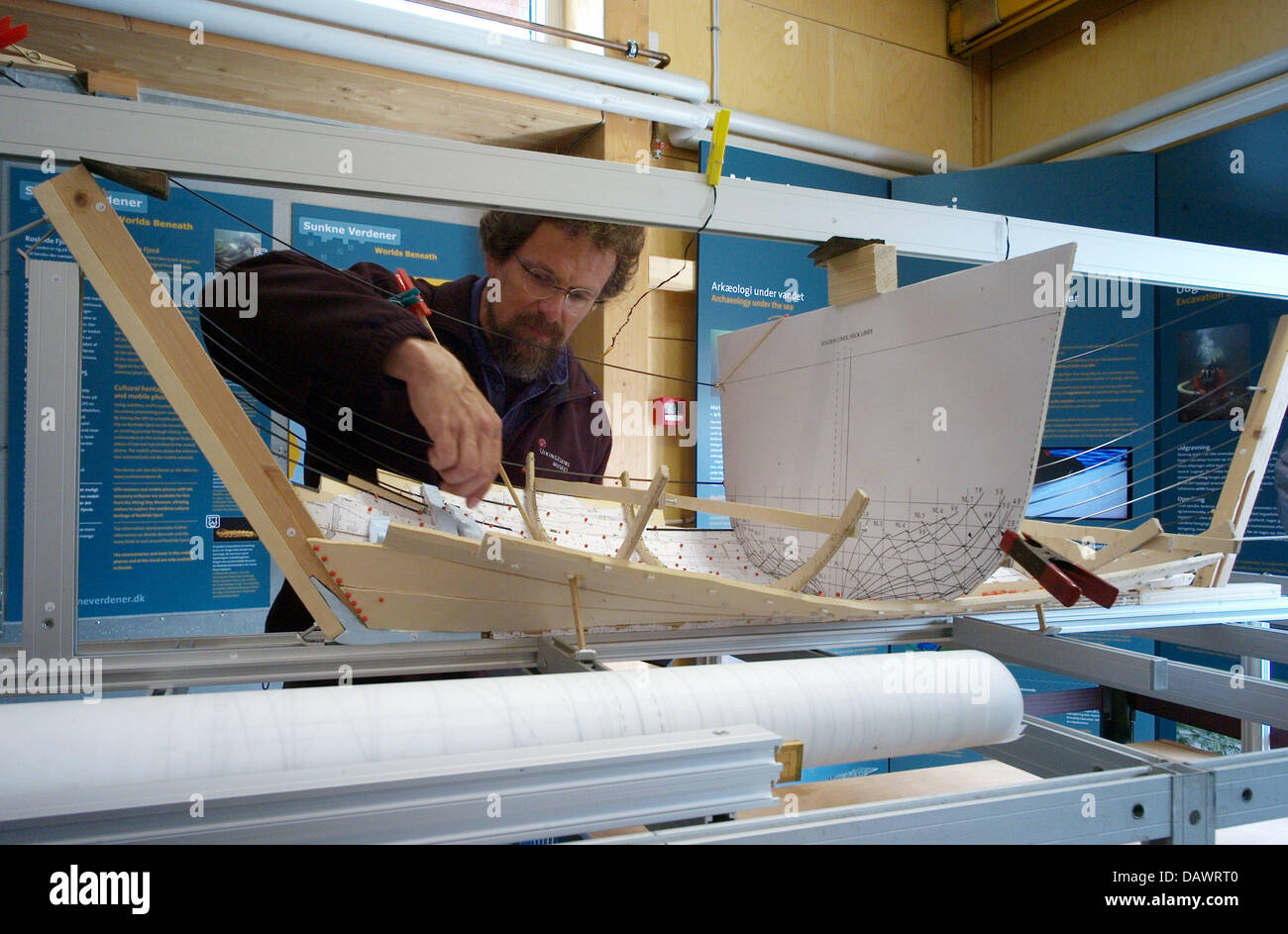 A visitor takes a look at a model of a Viking ship in the archeological workshop of the museum for Viking ships in Roskilde, Denmark, 22 May 2007. The model represents the most ambitious Viking ship project in the world. The long boat Skuldelev 2, a Viking warship with 30 metres length, is currently being reconstructed with tools from the Viking age. On 01 July 2007 it is going to Stock Photo