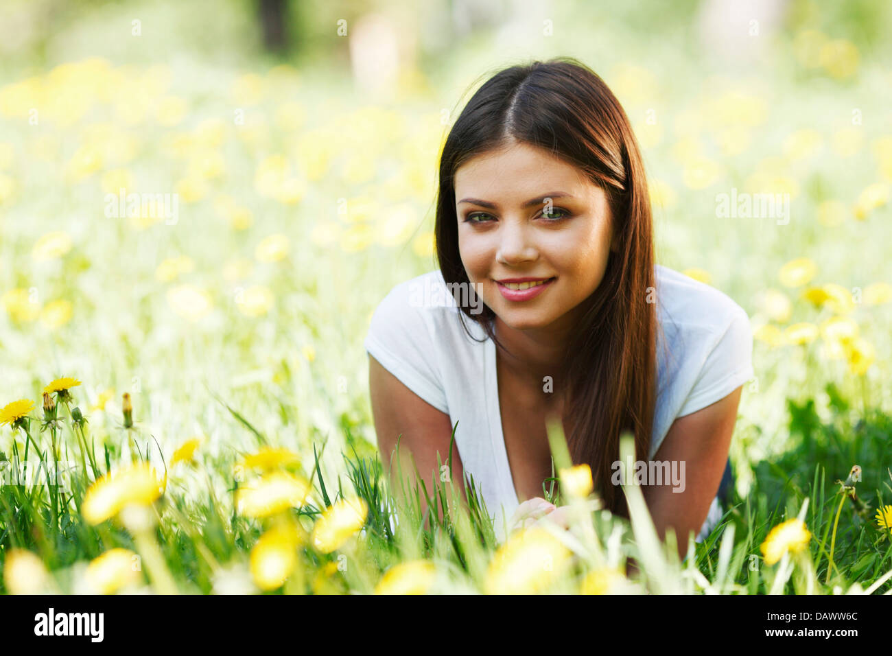 Beautiful young woman lying on grass with flowers Stock Photo - Alamy