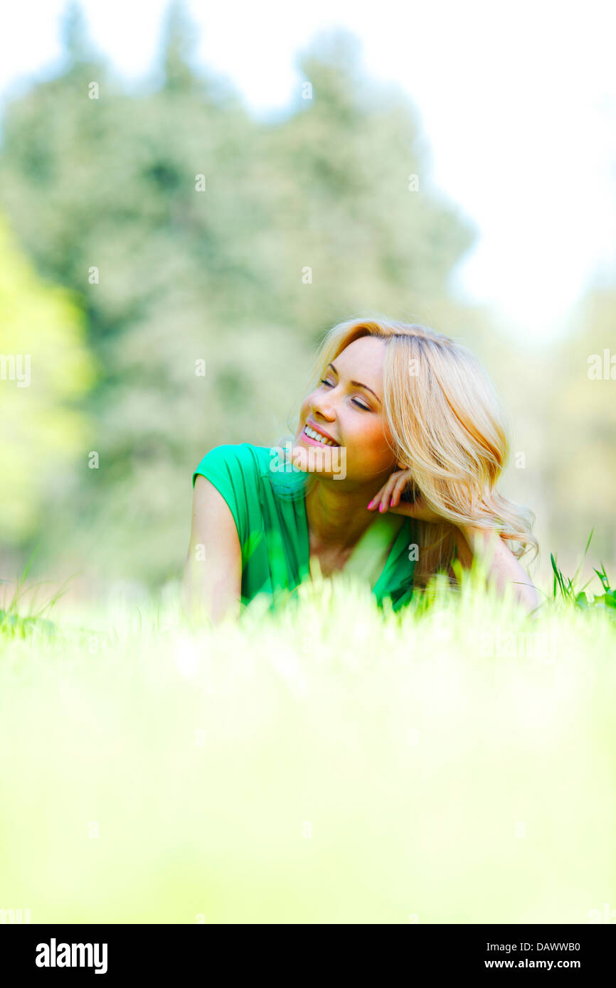 Happy young woman lying on grass Stock Photo - Alamy