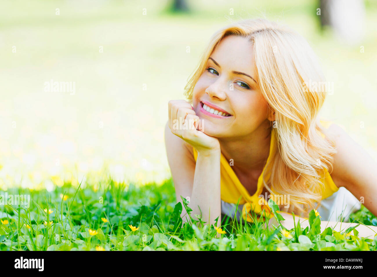Happy young woman lying on grass Stock Photo - Alamy