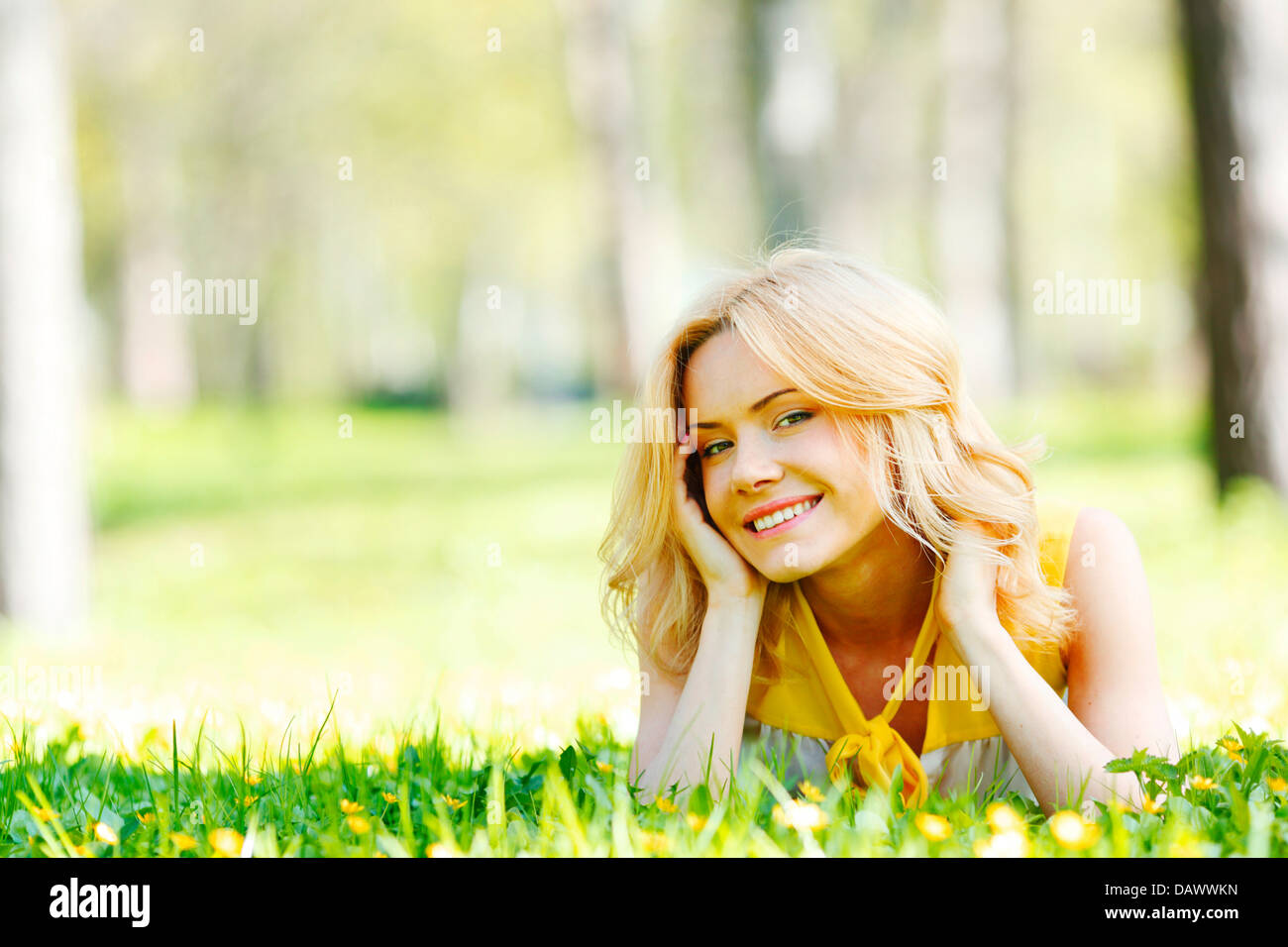 Happy young woman lying on grass Stock Photo - Alamy