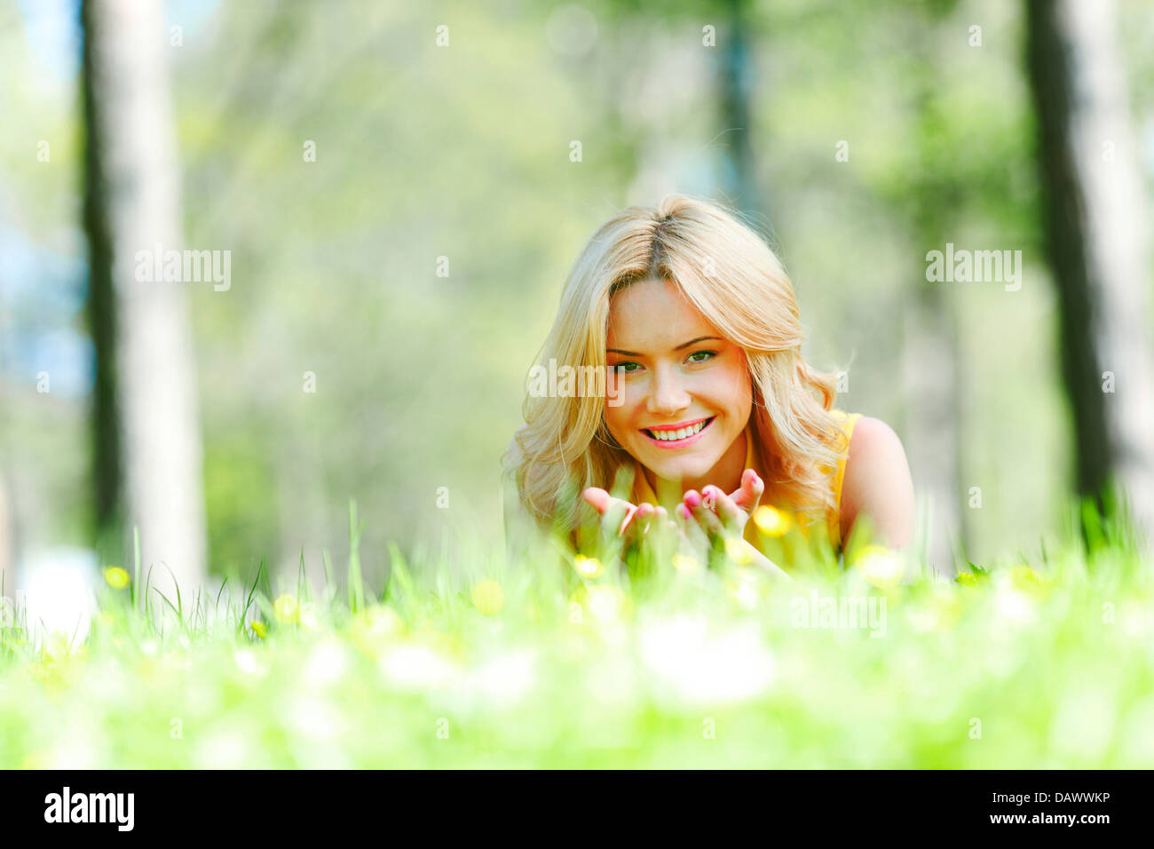 Happy young woman lying on grass Stock Photo - Alamy