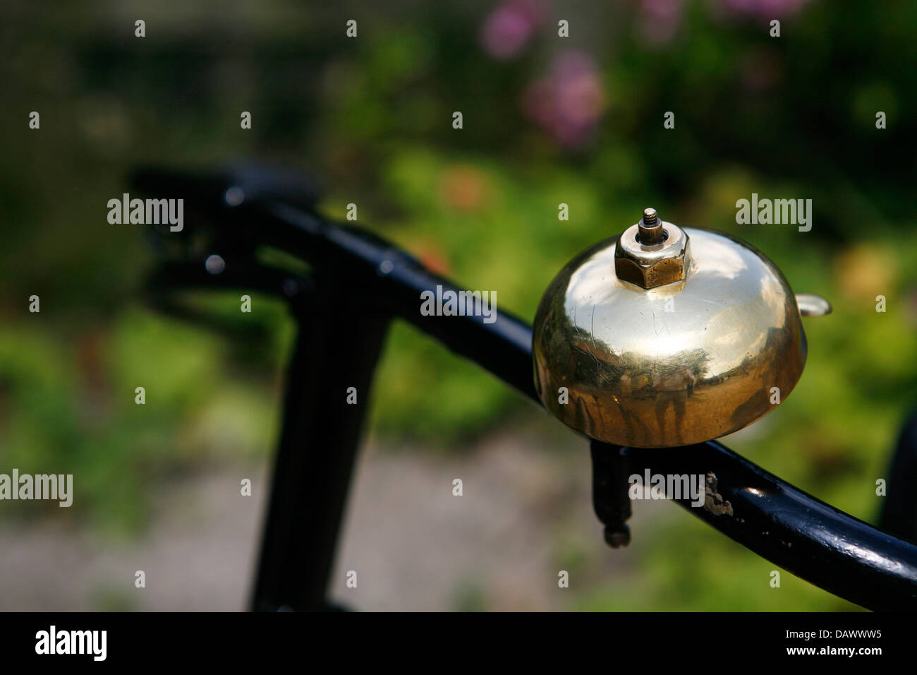Antique brass bicycle bell on a bike handle bars. Stock Photo