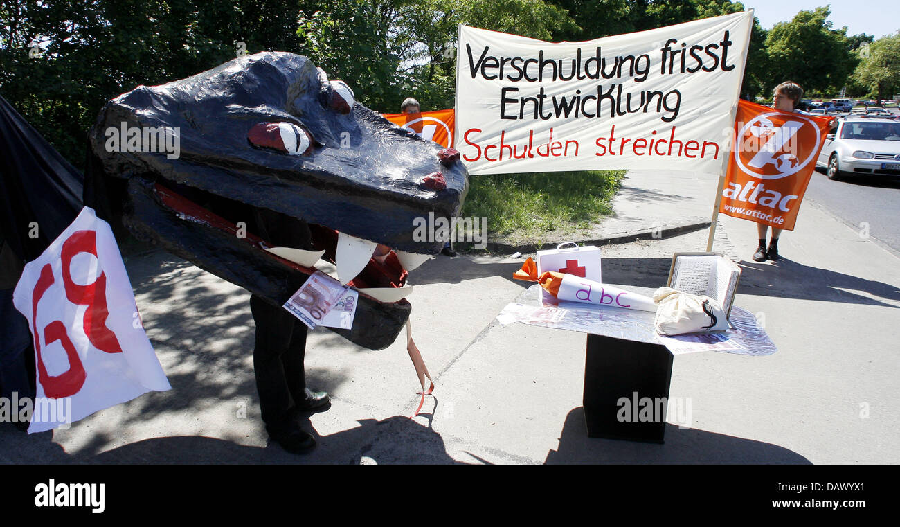 A poster reads 'Debt eats development - Cut debts' at an 'Attac' protest against a meeting of the G8 Ministers of Finance in Petzow, Germany, 18 May 2007. 'Attac' wants to call attention to the unsolved debt crisis. The Ministers of Finance of the G8 countries meet until Saturdaym 19 May. Photo: Bernd Settnik Stock Photo