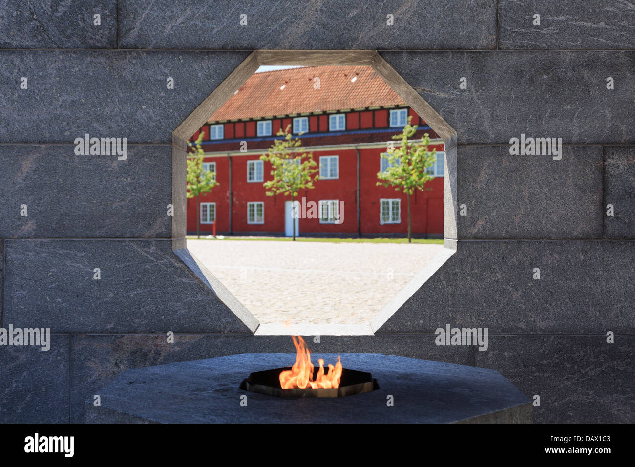 Eternal flame and by window in granite wall in Danish National Monument of Remembrance war memorial Kastellet Copenhagen Denmark Stock Photo