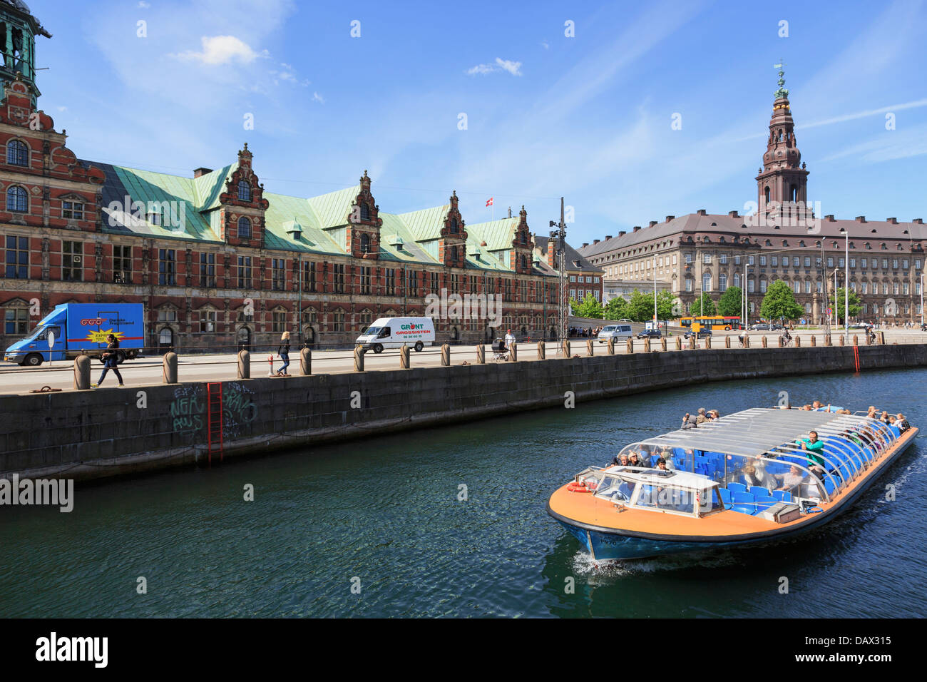 Tourists canal boat city sightseeing tour by Old Stock Exchange building Borsen and Christiansborg Palace in Copenhagen Denmark Stock Photo