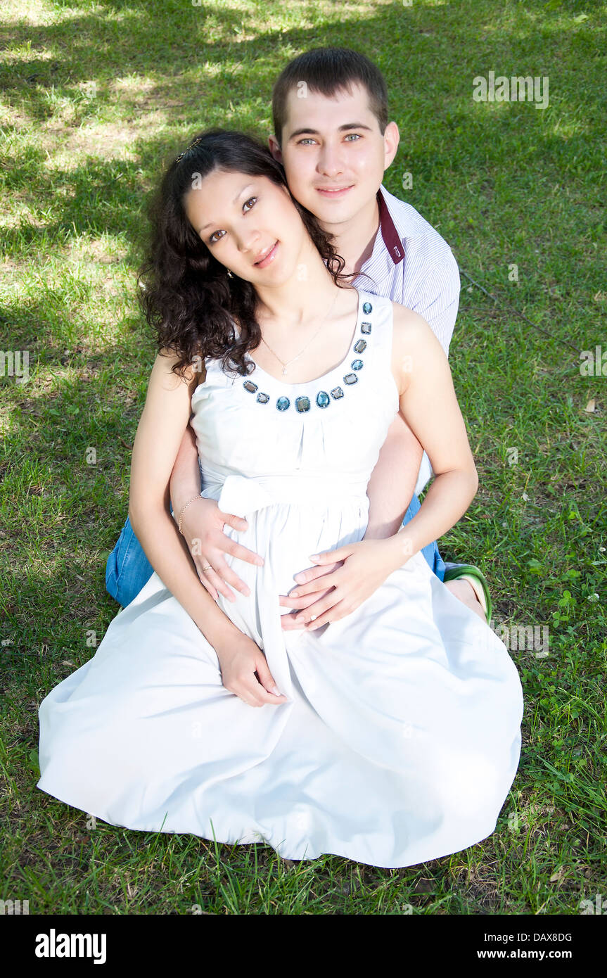 Man and pregnant woman hugging in park Stock Photo - Alamy