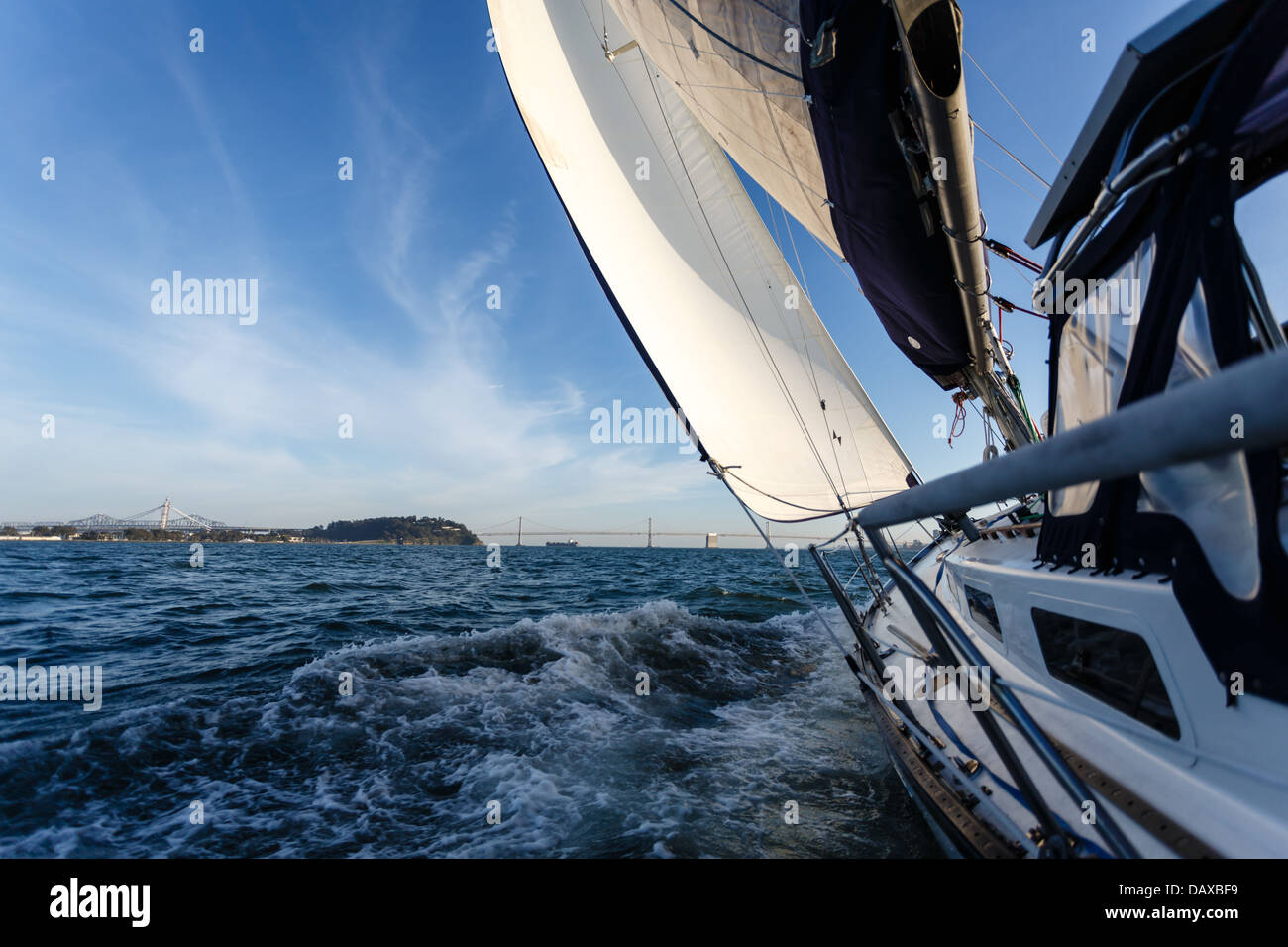 Side view of racing sailboat as it heads for the Bay Bridge in San Francisco Bay on a sunny day Stock Photo