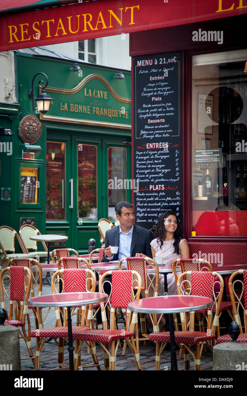 Couple enjoys cup of coffee at sidewalk cafe in Montmartre, Paris France Stock Photo