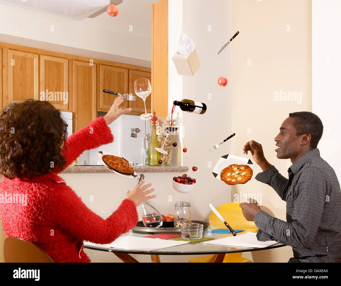 Couple sit at mealtime but everything they need is up in the air Stock Photo