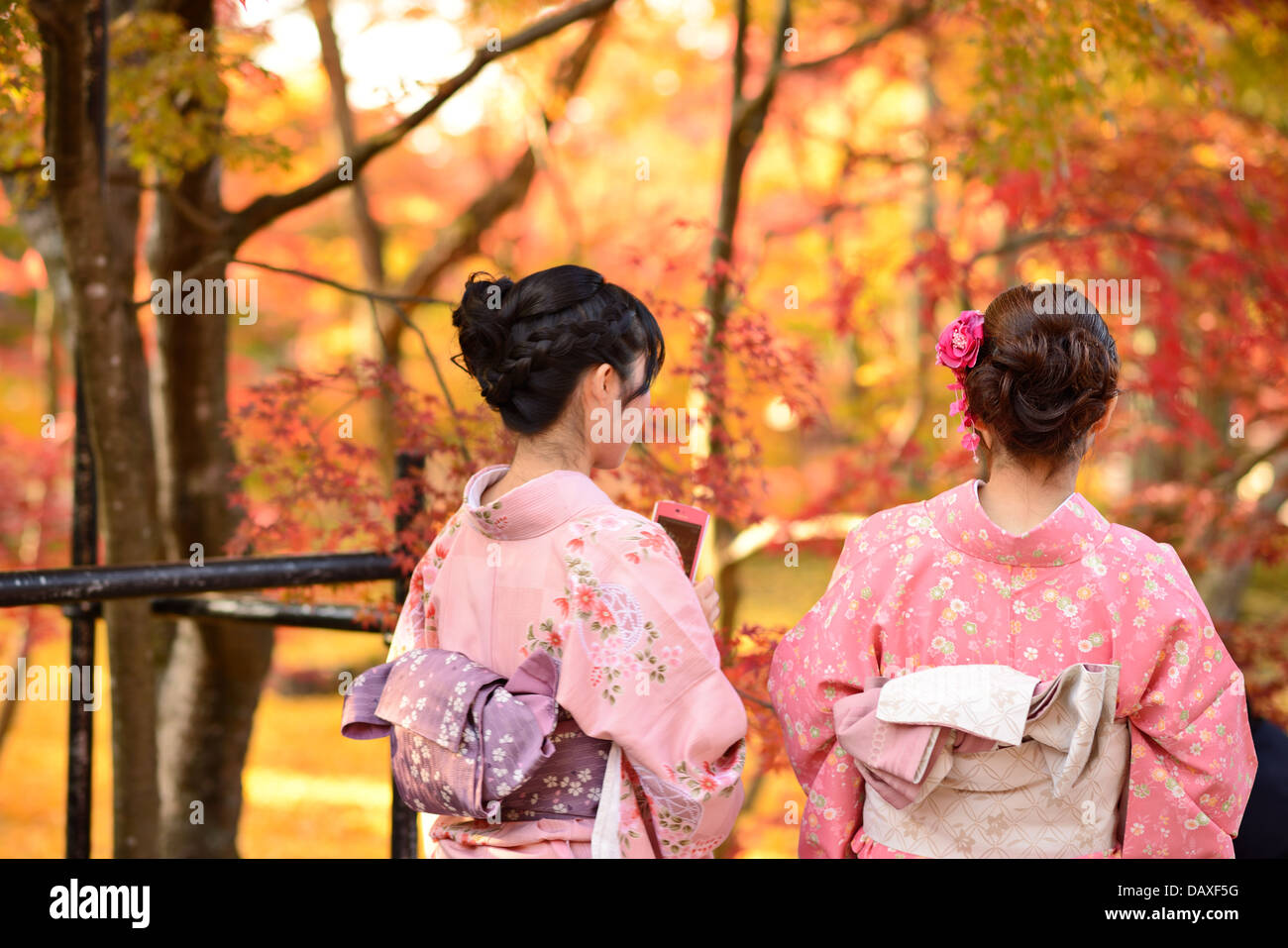 Girls view fall foliage in Kyoto, Japan. Stock Photo