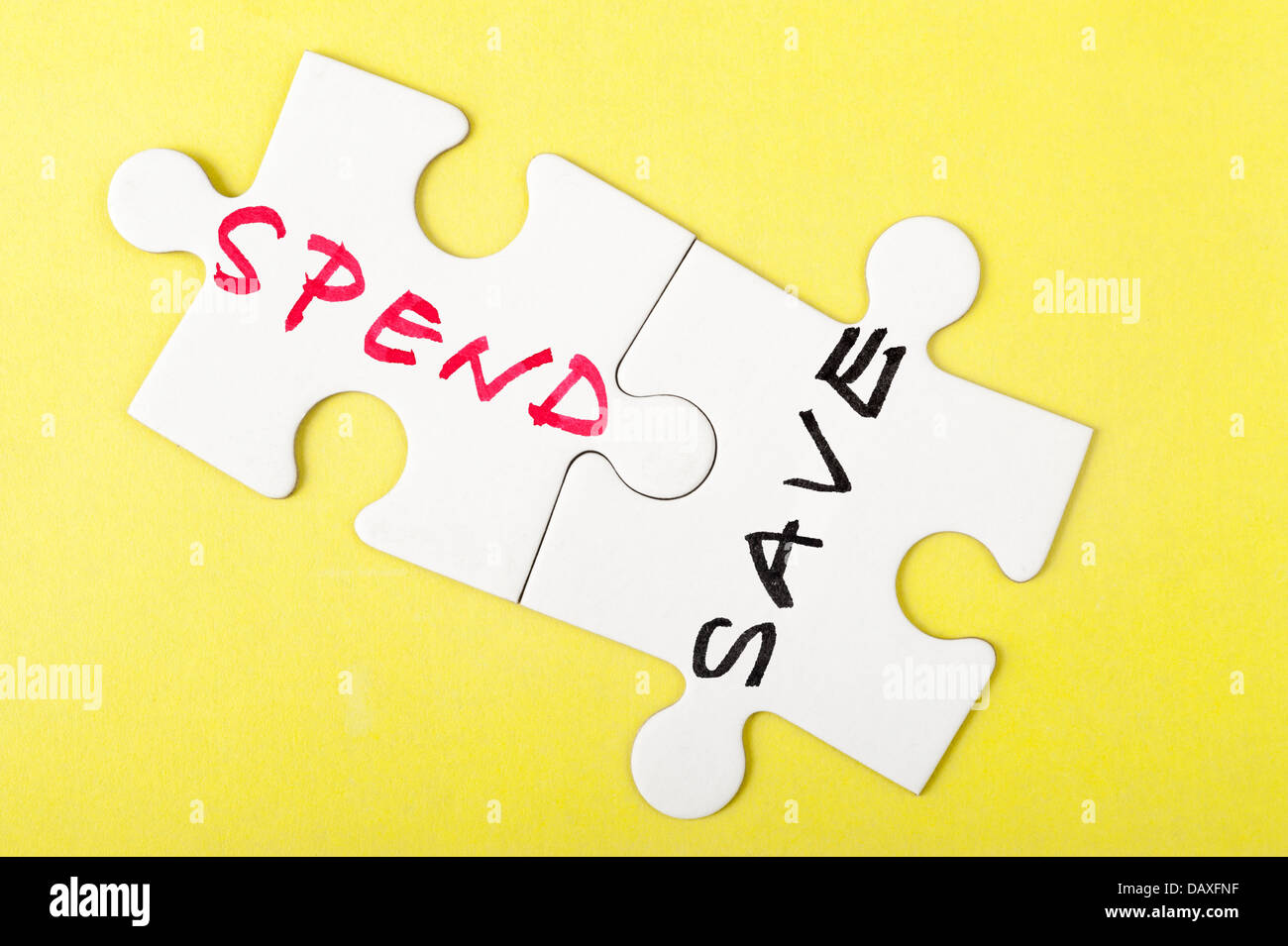 Spend and save words written on two pieces of puzzle Stock Photo