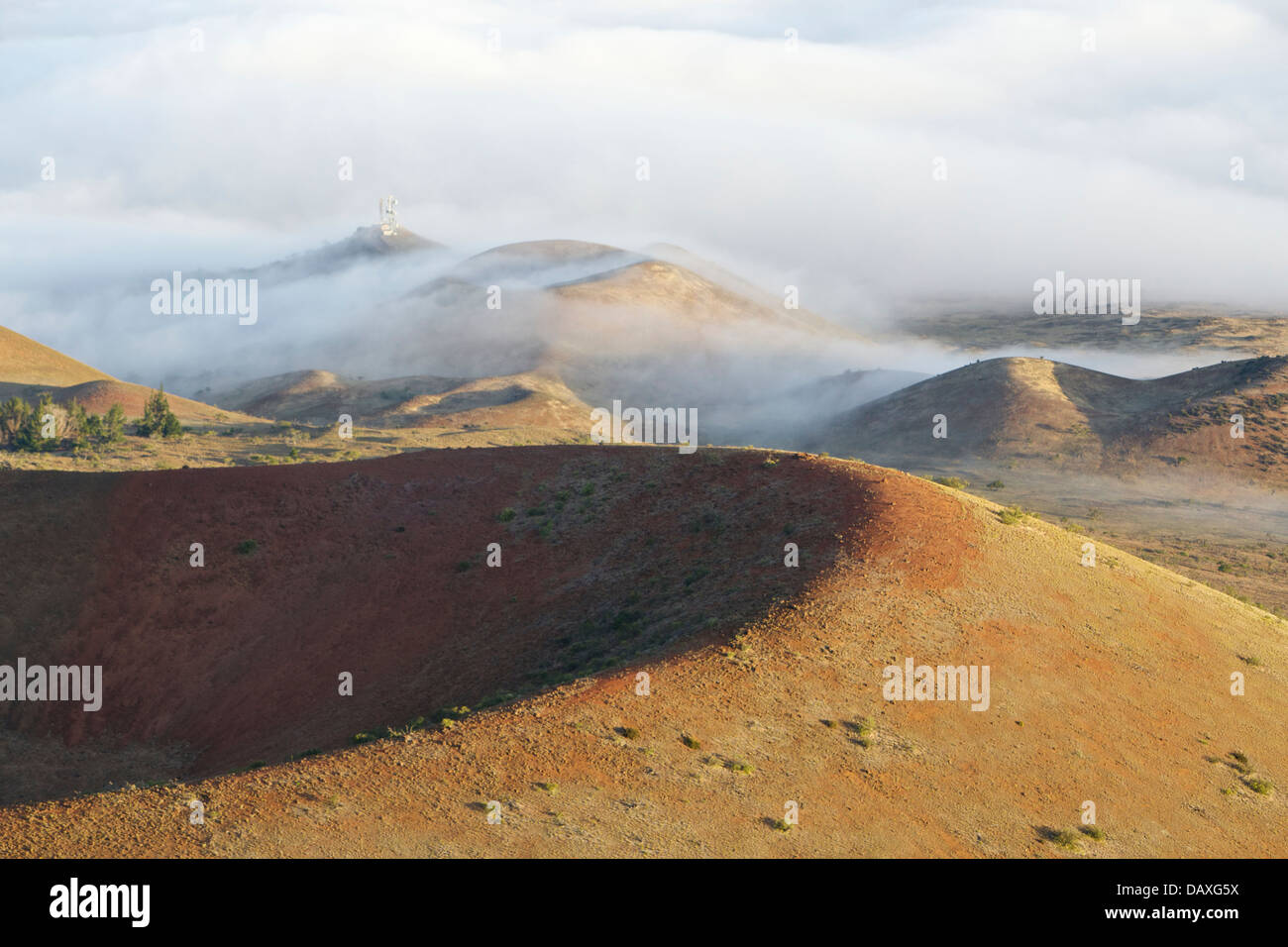 Clouds flowing over cinder cones on the flanks of dormant volcano Mauna Kea, on the Big Island of Hawaii. Stock Photo