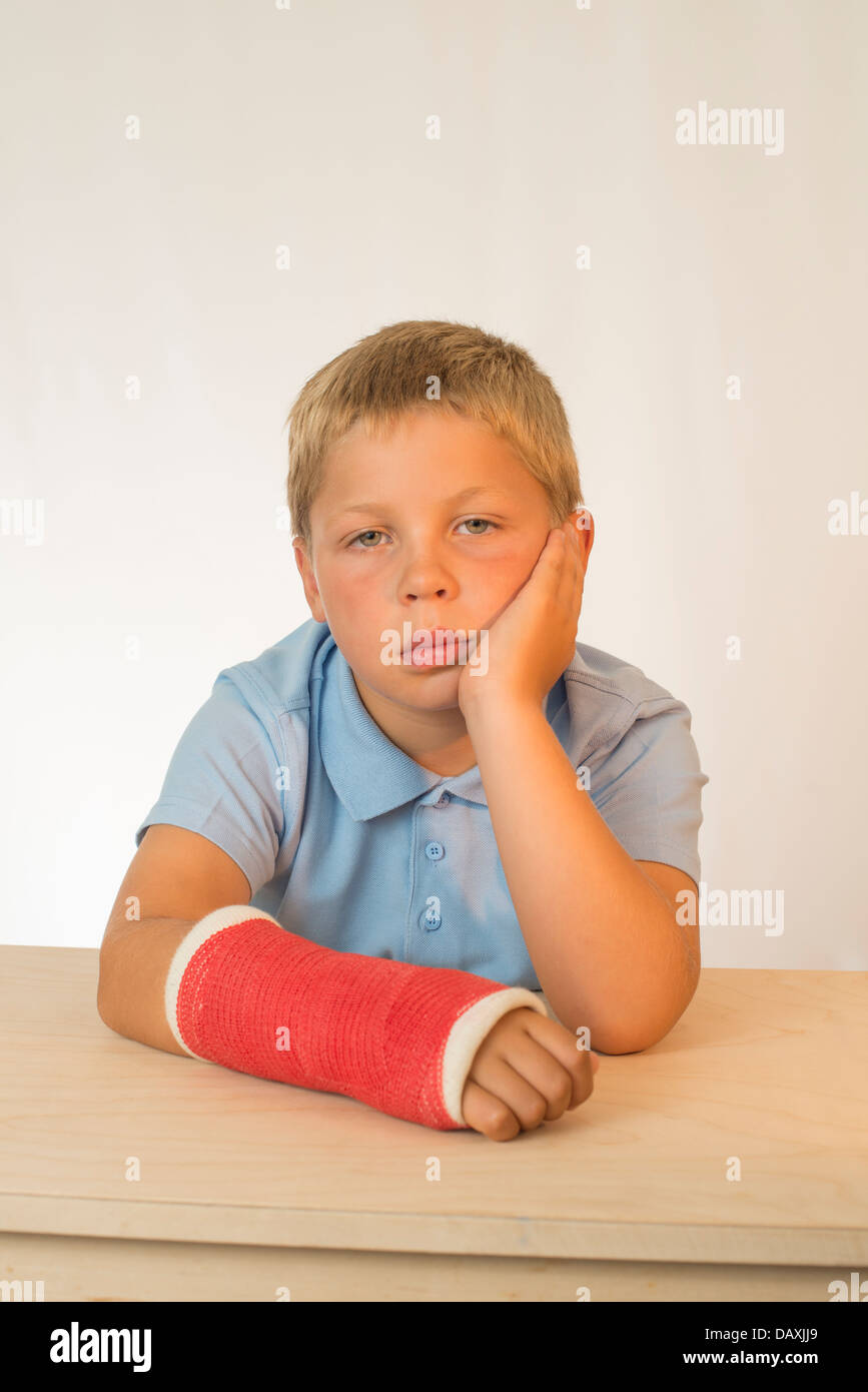 Sad young boy with arm in plaster cast. Stock Photo