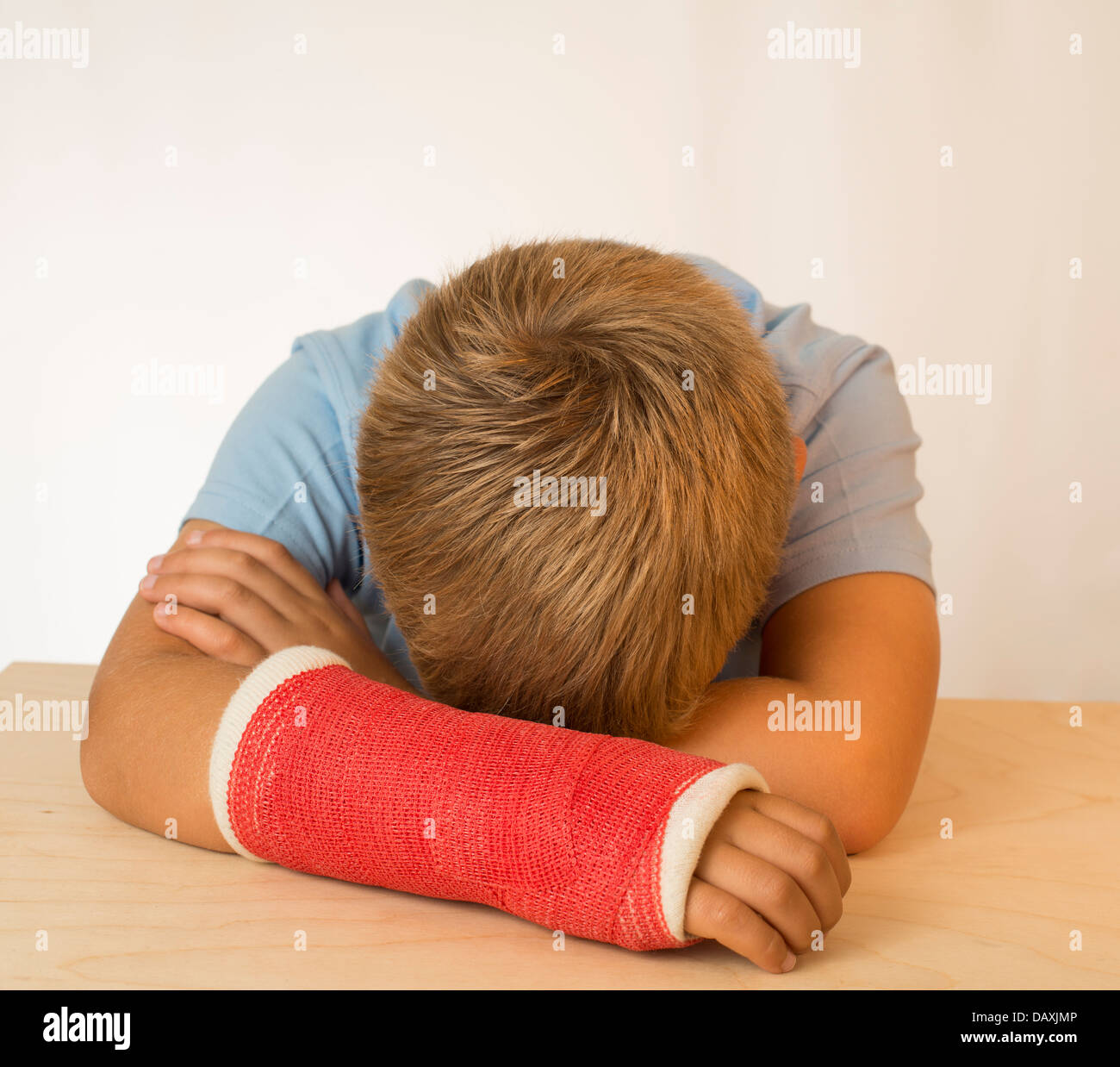 Sad young boy with arm in plaster cast. Stock Photo