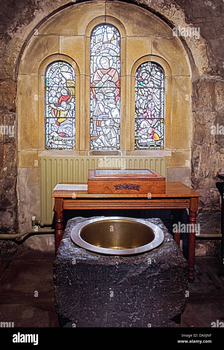 Baptismal font inside Saint Nicholas Church of Ireland, Carrickfergus, which dates back to around 1182 Stock Photo