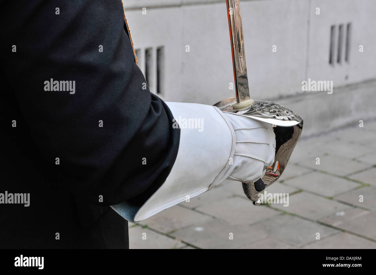 An Orangeman wears a glove and holds a ceremonial sword Stock Photo
