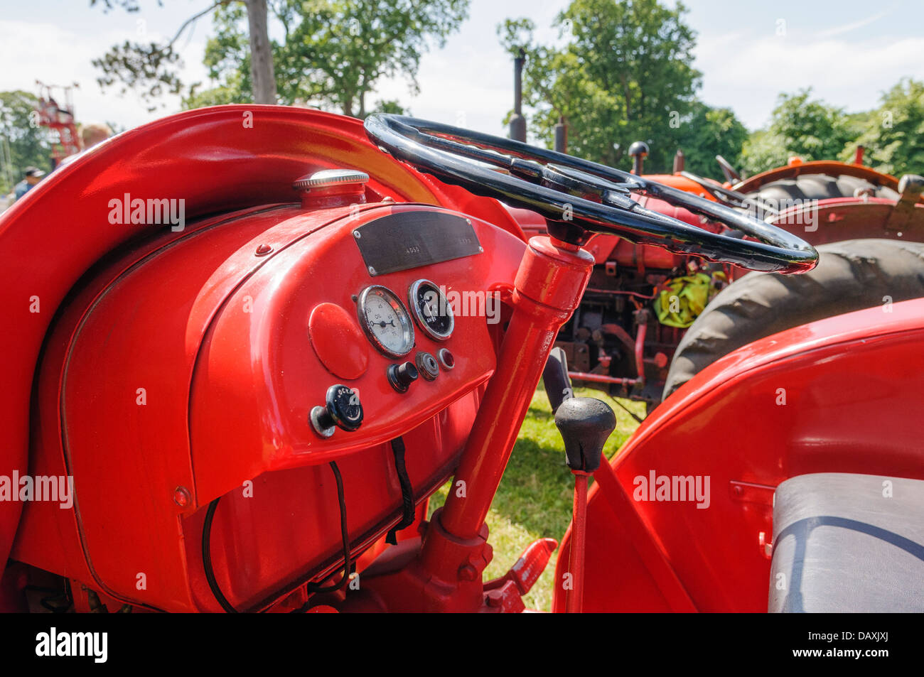 Steering wheel, controls and guages on a red vintage tractor Stock