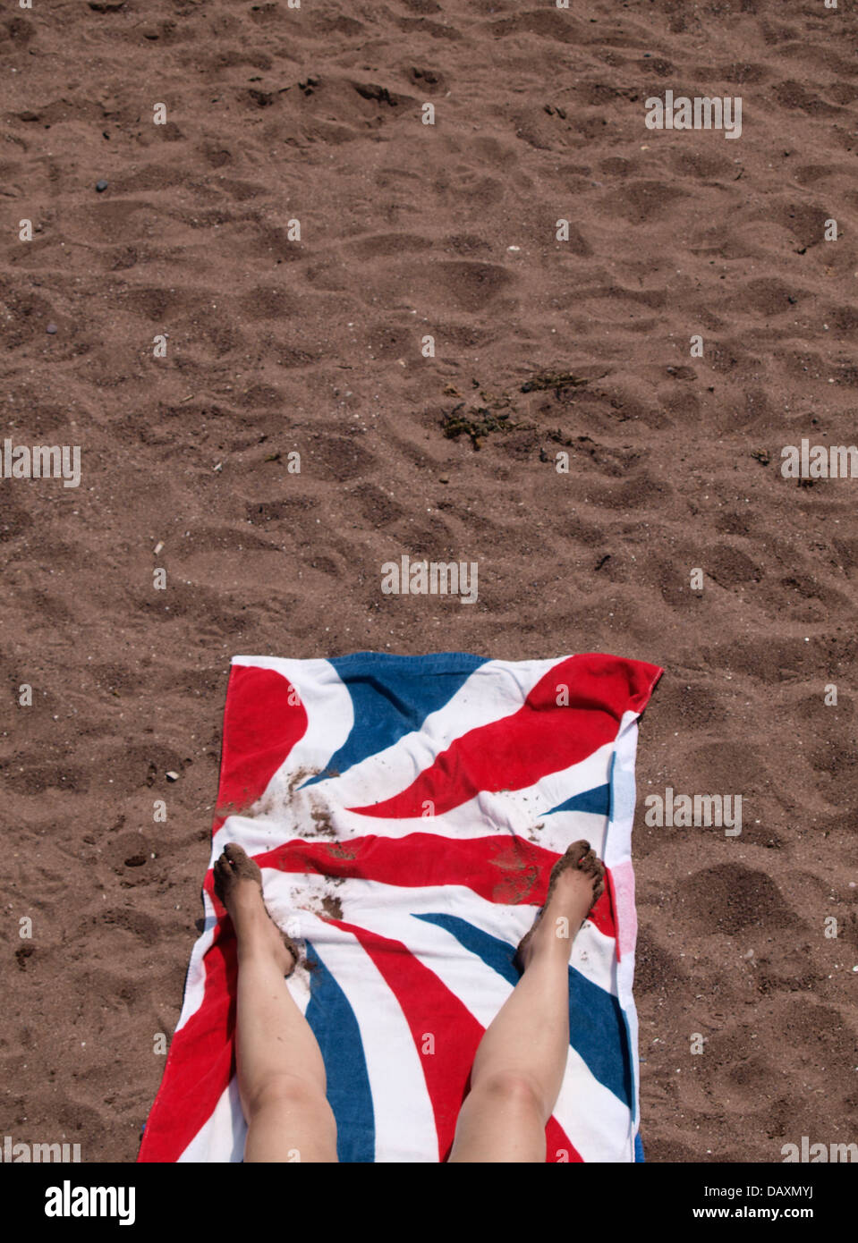 Legs of a woman sunbathing on Union Jack flag towel, UK 2013 Stock Photo