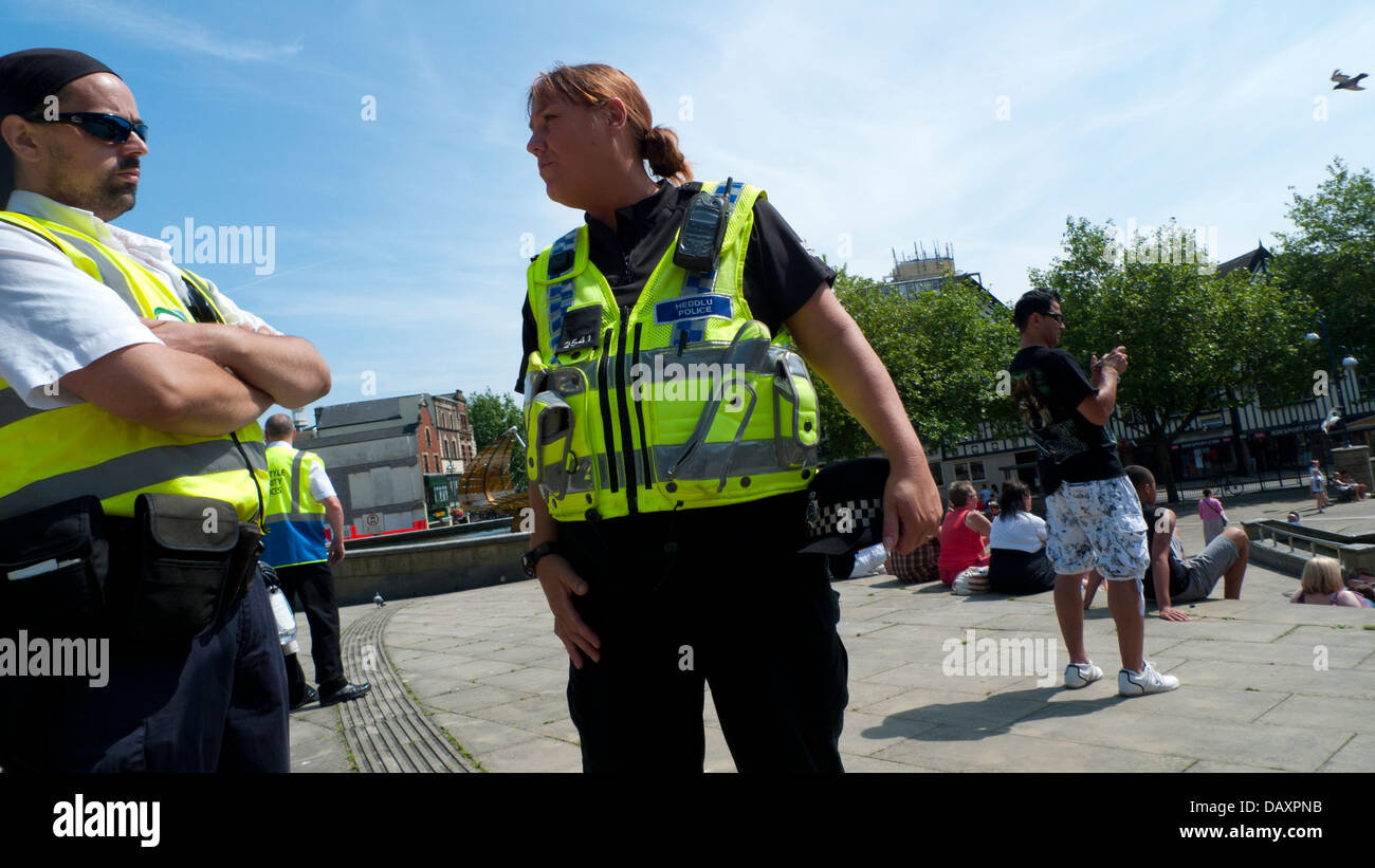 Female police officer talking to male police officer on work duty in summer in the city streets of Swansea South Wales UK  KATHY DEWITT Stock Photo