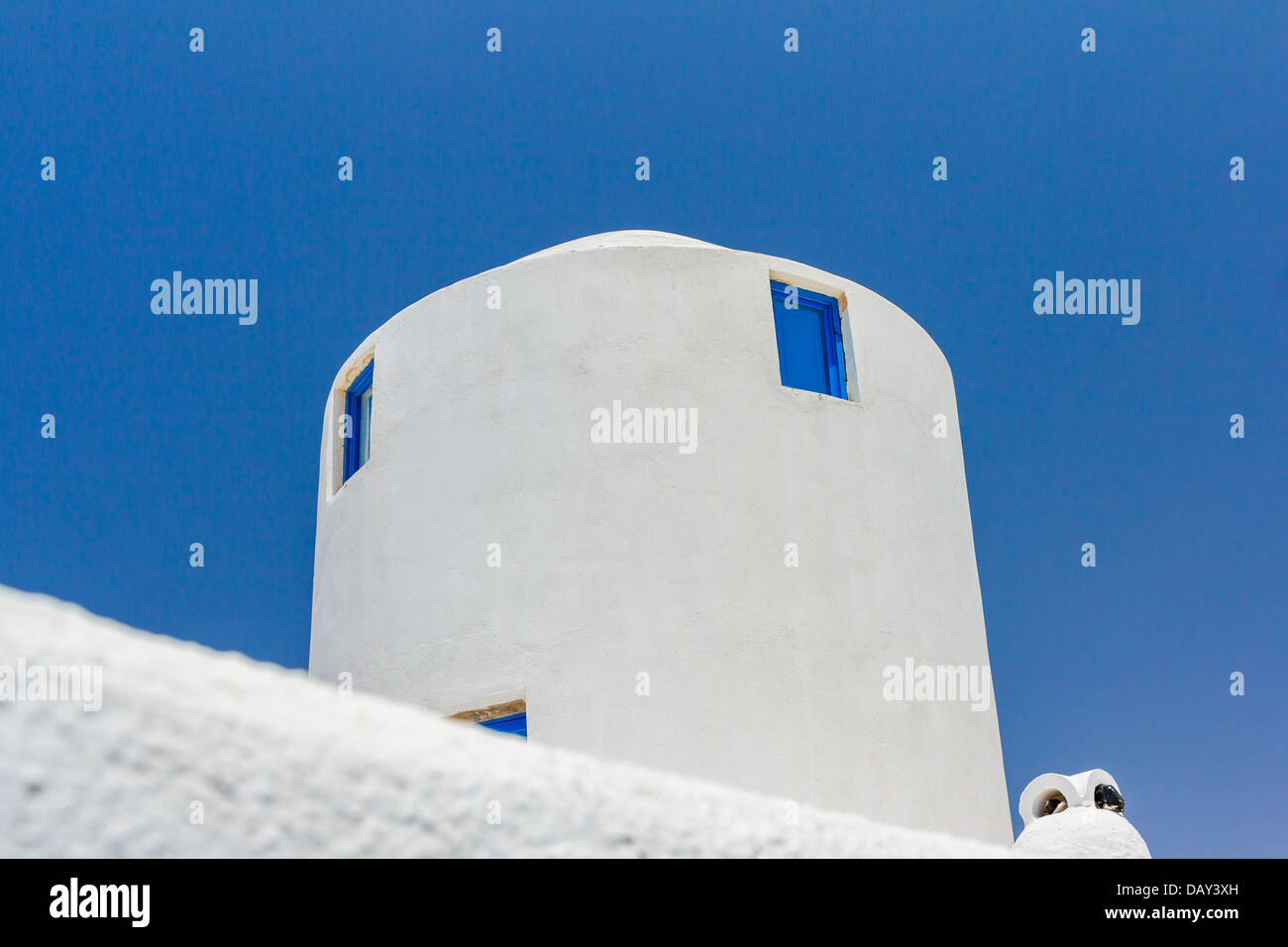 Traditional white windmill-house with blue sky as background at Santorini in Greece Stock Photo