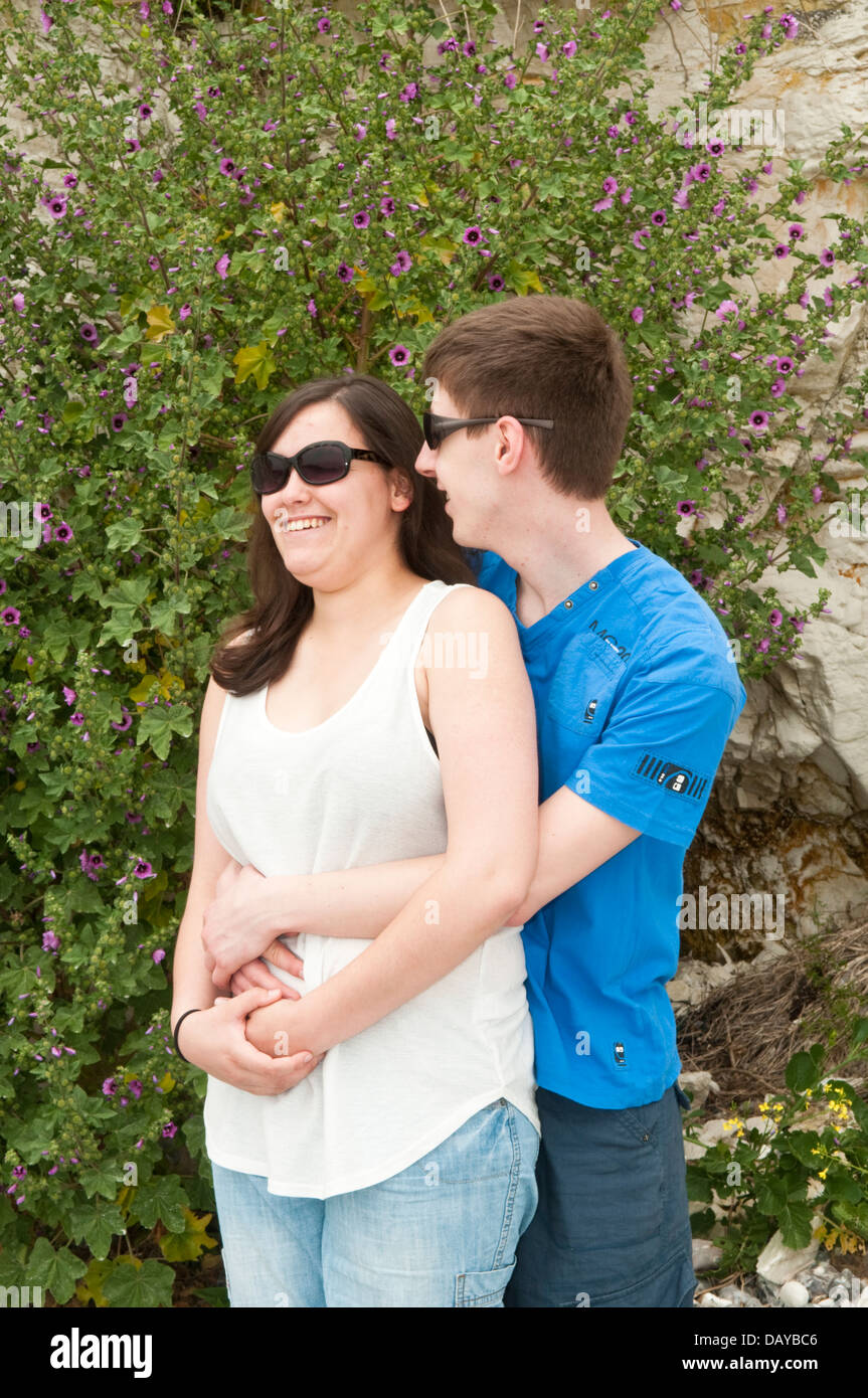 A young relaxed couple in their late teens or early twenties wearing casual clothing and sunglasses Stock Photo