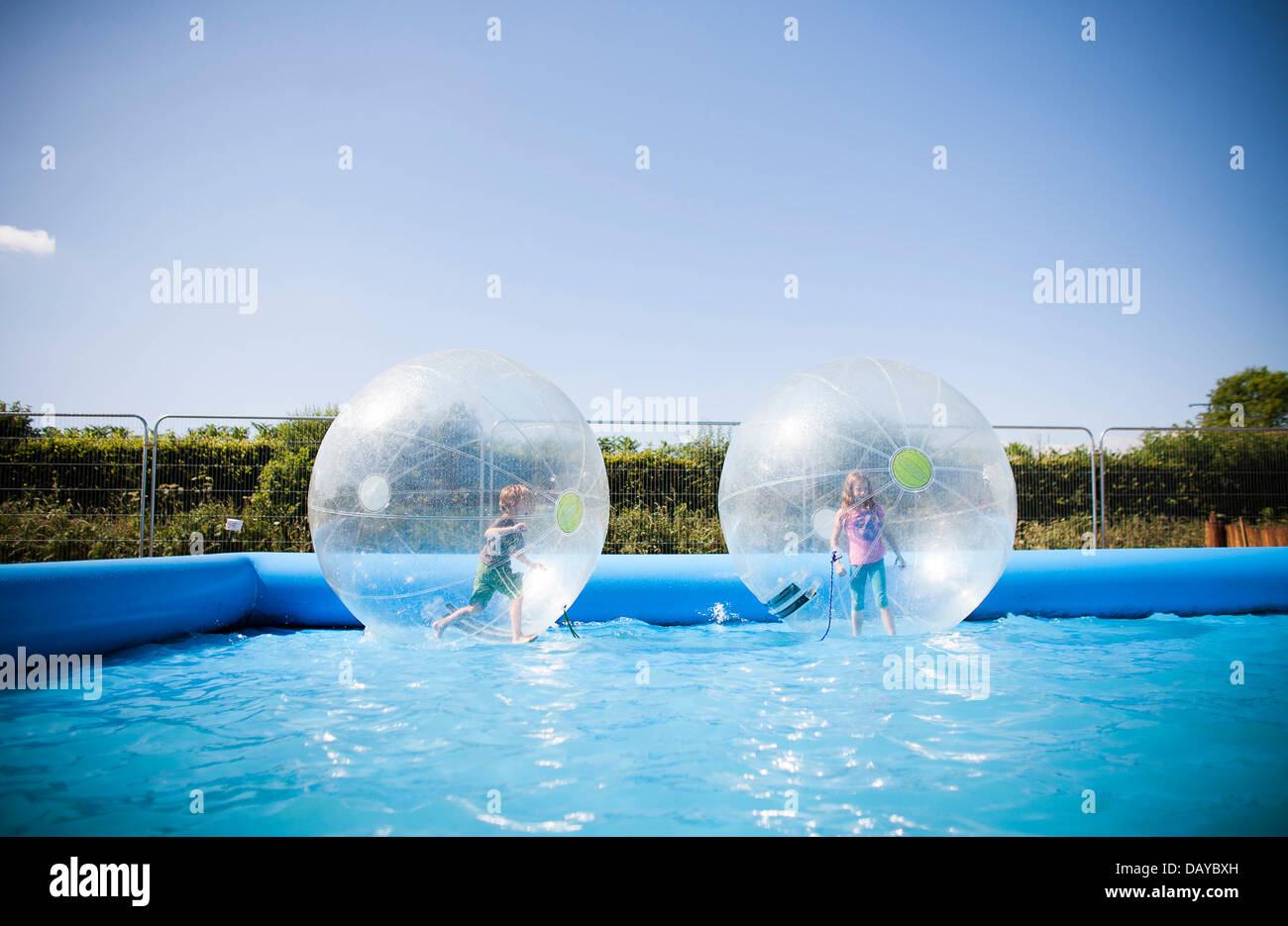 Oakhampton, UK. 20th July, 2013. People play in Zorb balls in a pool at Chagstock, a small music festival near Okehampton, Devon. The sold out event saw festival goers enjoying the hot, sunny weather that has basked the UK recently. The Met Office has downgraded the heatwave warning level but temperatures are expected to rise again during the next week. 20 July 2013 Credit:  Adam Gasson/Alamy Live News Stock Photo