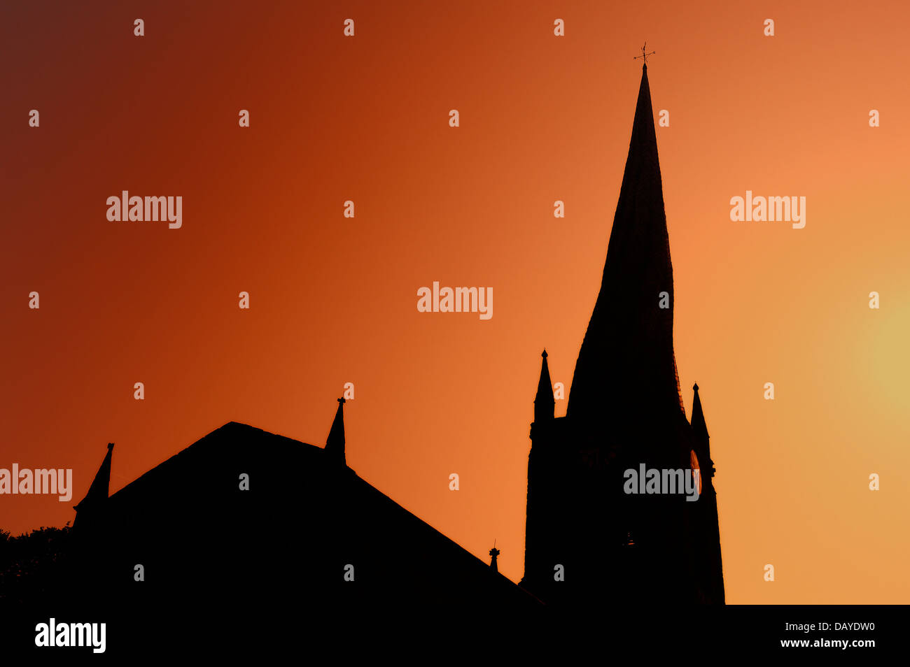 The twisted spire of Chesterfield Parish Church Derbyshire England United Kingdom against a flame red sky Stock Photo